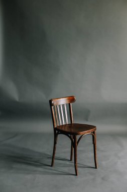Gri arka planda bir sandalye. Tarafsız iç mekan. Boş gri duvar arka planında ahşap sandalye. İç tasarım kavramı.