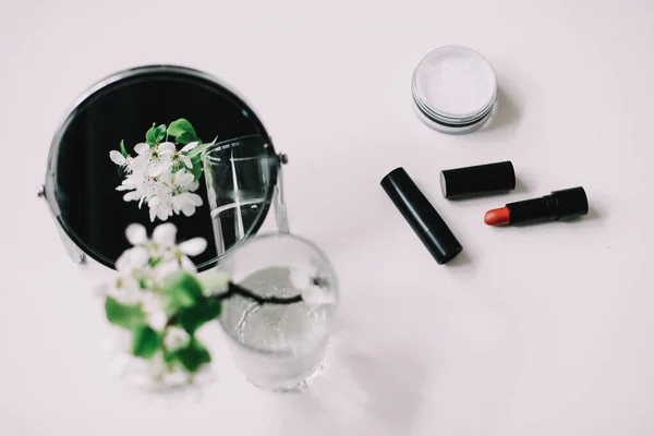 花、化粧品、ドレッシングテーブルの上からの鏡。女性のアクセサリーとフラットレイアウト。化粧品組成. — ストック写真