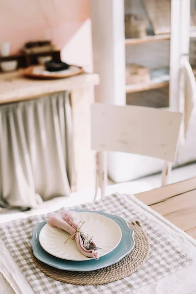 Elegant table setting. Table set for fine dining with metal fork and linen napkins on a plate. Home decor rustic table setting