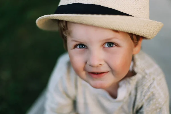 Retrato de cerca de un niño sonriente al aire libre. Un hermoso chico lindo en un sombrero —  Fotos de Stock