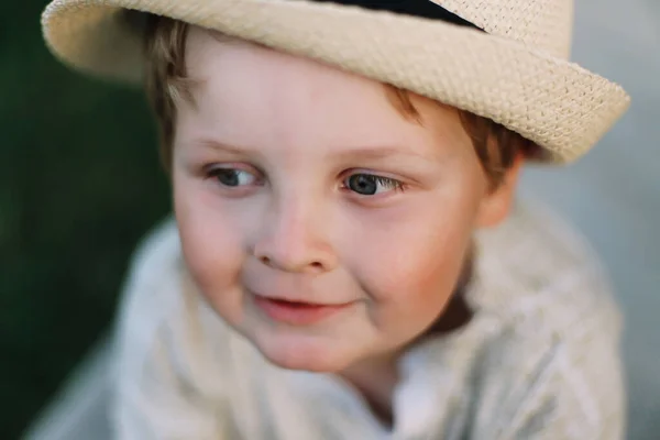 Retrato de cerca de un niño sonriente al aire libre. Un hermoso chico lindo en un sombrero —  Fotos de Stock