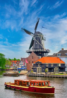 A windmill along the canals in Haarlem, Netherlands on a clear day. clipart
