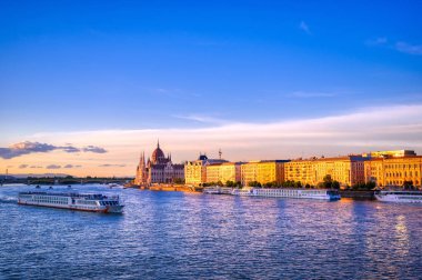 Macaristan 'ın Budapeşte' deki Tuna Nehri üzerindeki Macar Parlamento Binası gün batımında.