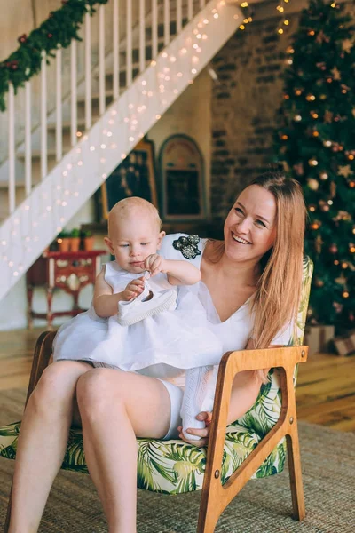 Una joven madre con su hija pequeña cerca del árbol de Navidad —  Fotos de Stock