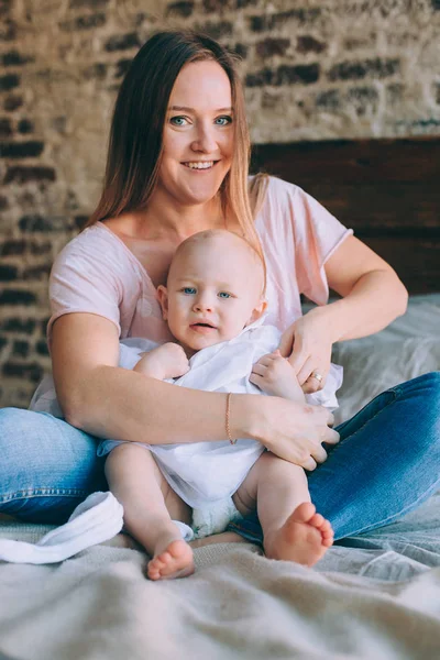 Mãe veste a filha, em um vestido branco e meia-calça — Fotografia de Stock