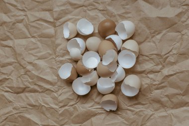 Kırık, boş yumurta kabuğunun buruşmuş kahverengi bir kraft kağıdındaki dokusu. Yukarıdan bak. Kopyalama alanı.