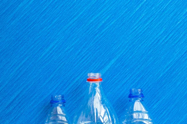 Recycling. Materials for recycle and reuse plastic bottle, tin can on blue background. Top view. Flat lay