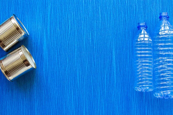 Recycling. Materials for recycle and reuse plastic bottle, tin can on blue background. Top view. Flat lay