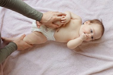 Anne ve tatlı çocuğunun yataktaki en güzel görüntüsü. Bebek masajı ve jimnastik egzersizleri..