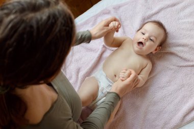 Anne ve tatlı çocuğunun yataktaki en güzel görüntüsü. Bebek masajı ve jimnastik egzersizleri..