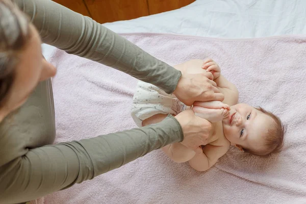 Anne sırt ve yeni doğmuş bir bebeğe ayak masajı yapıyor. Annenin bakımı. sağlıklı yaşam tarzı.