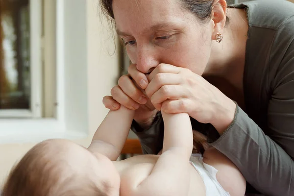 Joven Madre Besando Los Pequeños Pies Bebé —  Fotos de Stock