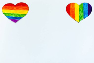 Beyaz arka planda LGBT bayrak renginde iki kalp. Romantik gey topluluğu randevusu.