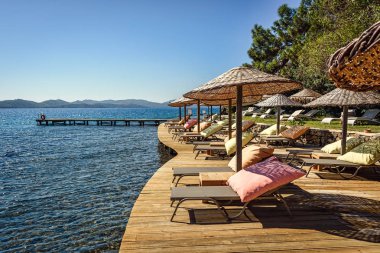 Şezlong ve sundshades deniz altında ahşap bir platformda