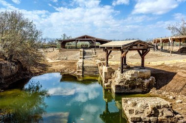 Authentic site of Jesus' baptism under blue skies with fluffy cl clipart