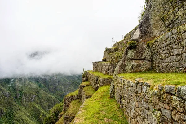 Terrasses agricoles vertes de l'ancienne citadelle inca sous un brouillard épais — Photo