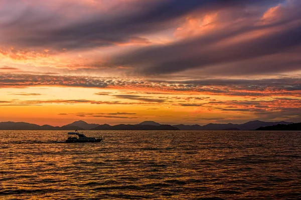 Золотий захід сонця на морі після шторму з темними хмарами — стокове фото
