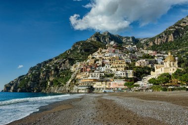 Deniz kıyısında vista ile kabarık beyaz bulutlar mavi gökyüzü altında