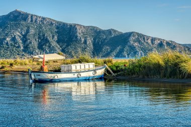 Sakin gölde g kumlu bir sahil şeridine bağlı bir balıkçı teknesi