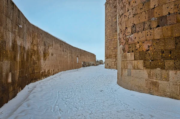 Rue recouverte de neige entre les murs d'une ville antique un — Photo