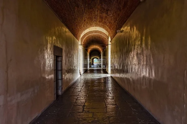 Dark corridor with pale yellow walls in an old palace