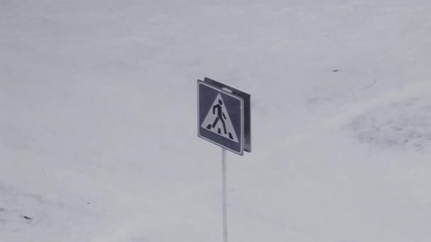 Снег падает на дорожный знак пешеходного перехода — стоковое видео