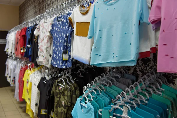 Camisetas en una percha en la tienda —  Fotos de Stock