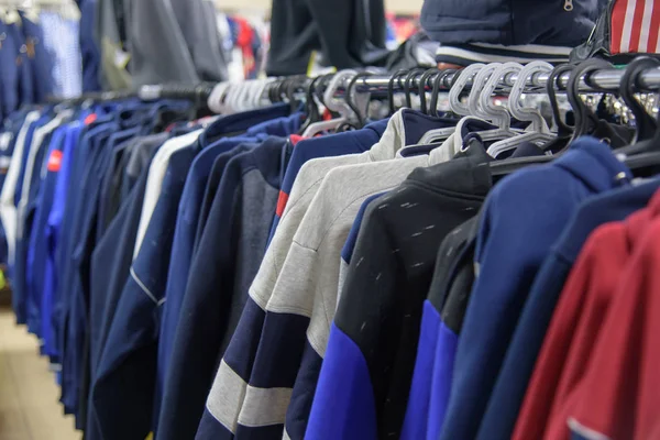 Sudaderas con capucha en la percha en tienda —  Fotos de Stock