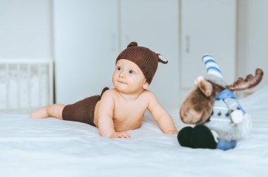 çok güzel bebek çocuk örgü geyik şort ve şapka oyuncak geyik ile yatakta