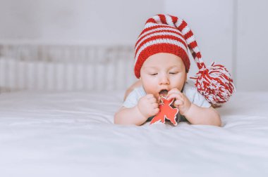bebek çocuk oyuncak melek yatakta oynamaktan pon pon ile kırmızı ve beyaz çizgili şapkalı