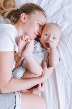 Anne ve bebek bebeği birlikte yatakta yatan bir Üstten Görünüm