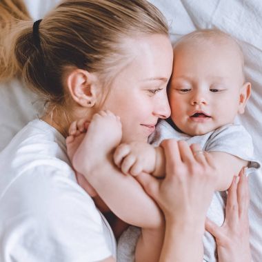 genç anne bebek çocuk yatakta kucaklayan yakın çekim vurdu