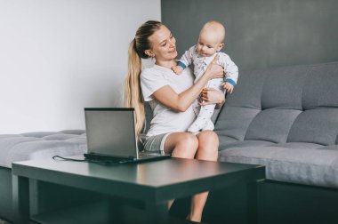 evde laptop kullanırken mutlu genç anne holding çok güzel bebek çocuk