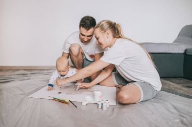 mutlu genç ailesi ile birlikte evde katta boyama sevimli küçük bebek çocuk  