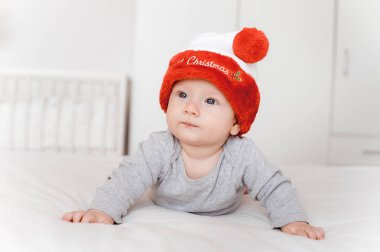 Noel Baba şapkası yatakta yatarken şirin küçük bebek çocuk portresi