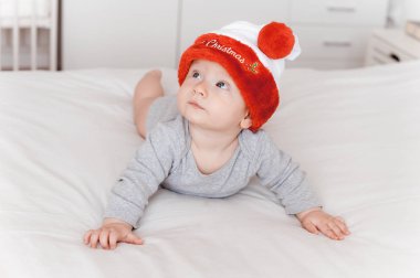 yatakta yatarken ve ararken santa şapka çok güzel bebek çocuk portresi