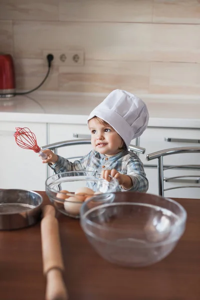 Adorable little kid in chef hat holding whisk in hand ready to cook — Stock Photo