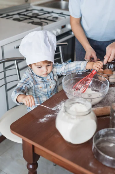 Мать и очаровательный маленький ребенок готовит тесто на кухне — стоковое фото