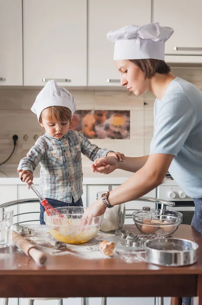 Mutter und Kind bereiten in der Küche Teig für Plätzchen zu — Stockfoto