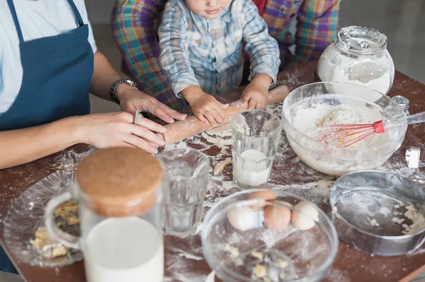 Cropped shot of family rolling dough with pin for cookies together — Stock Photo