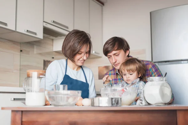 Schöne junge Familie bereitet Teig in der Küche zu — Stockfoto