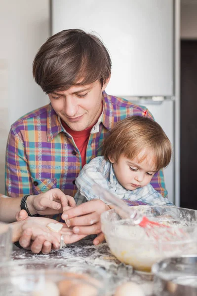 Joven padre e hijo preparando galletas en forma de corazón - foto de stock