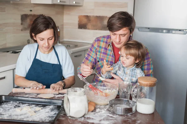Família feliz preparando massa para biscoitos caseiros juntos — Fotografia de Stock
