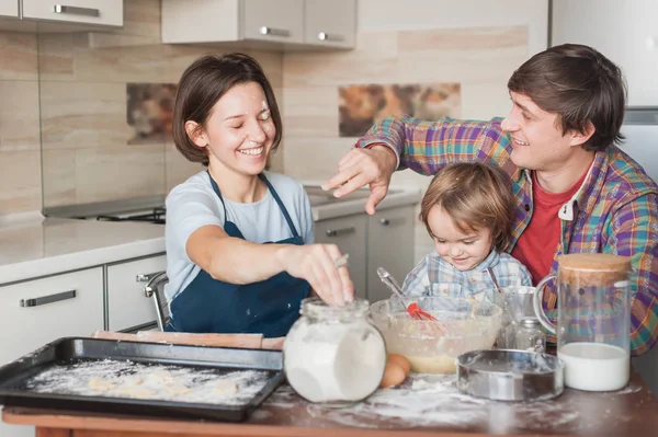 Playful young family preparing cookies together at home — Stock Photo