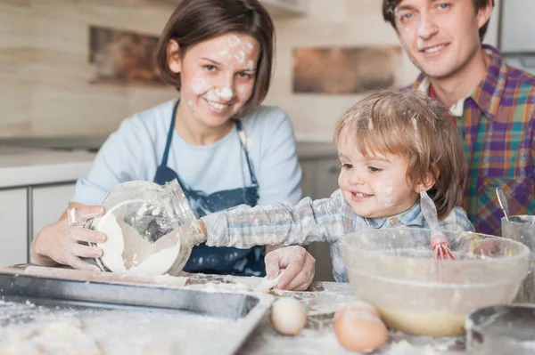 Entzückendes kleines Kind hilft seinen Eltern beim Kochen in der Küche — Stockfoto