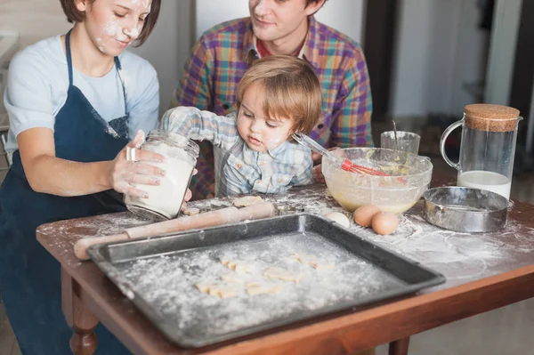 Little kid helping his parents with cooking at kitchen — Stock Photo