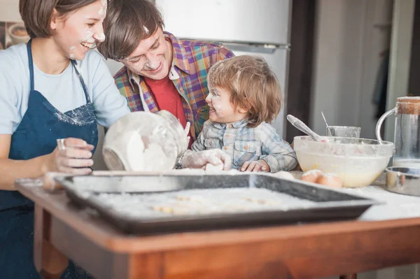 Feliz familia joven derramada con harina pasar tiempo juntos en la cocina - foto de stock
