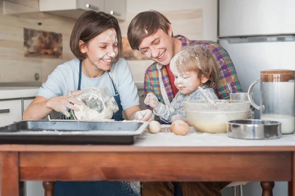 Jovem família derramado com farinha cozinhar juntos na cozinha — Fotografia de Stock