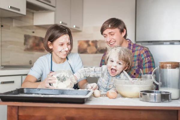Грязная молодая семья готовит с мукой вместе на кухне — стоковое фото