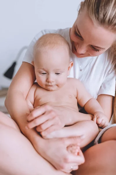 Gros plan de la jeune mère assise au lit avec son bébé — Photo de stock